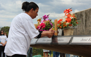Uma das viúvas depositando flores no Memorial